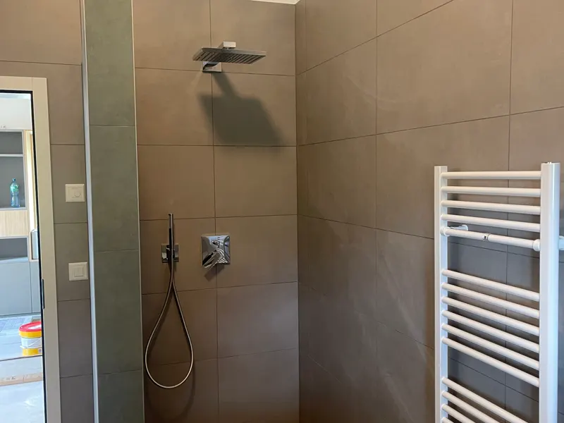 Douche à l'italienne en grès cérame taupe grand format posée par GPN Sàrl
